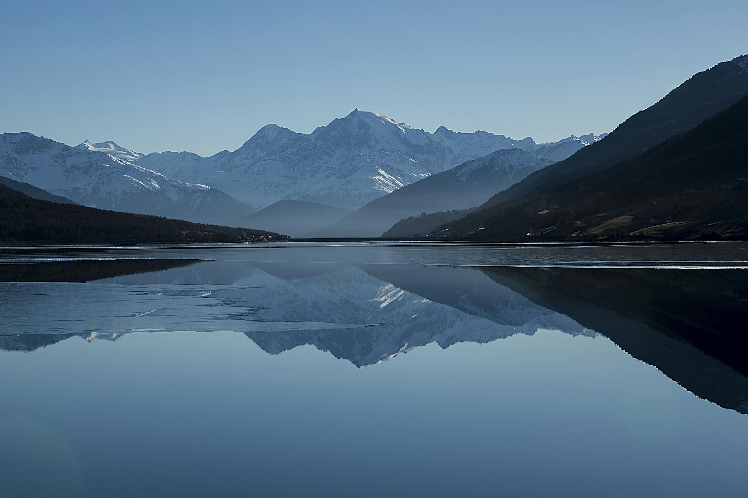 Calm Body of Lake Between Mountains